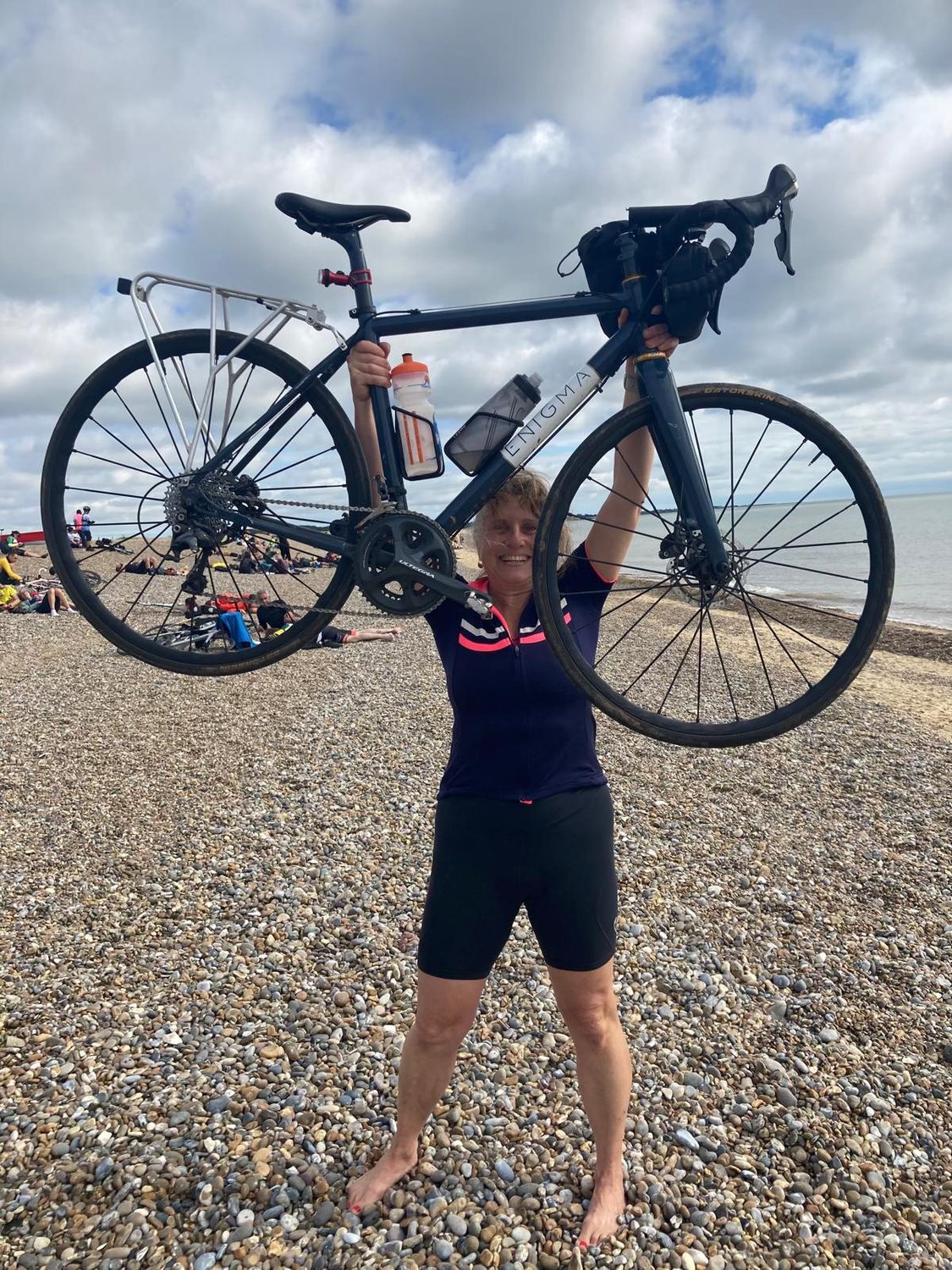 image of a woman holding a bike above her head and smiling