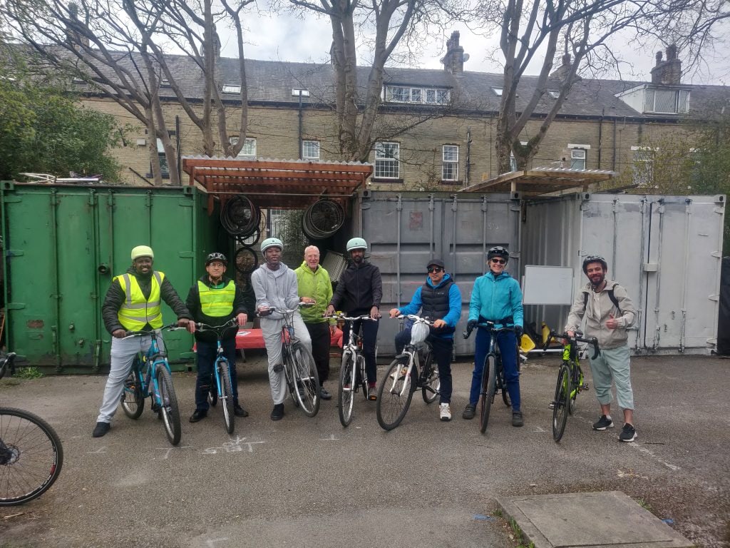 a group of people with helmets on and on bikes about to go for a ride.
